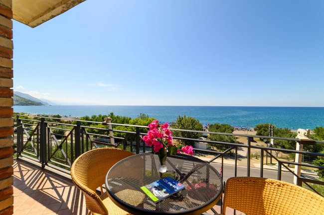 Balcone con tavolo e fiori, vista mare.