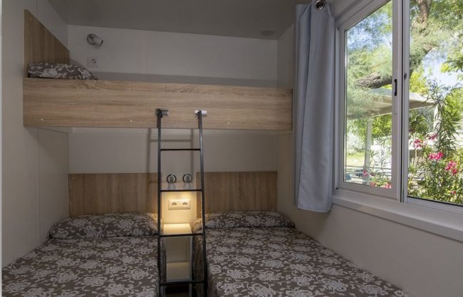 Due letti a castello in una stanza con finestra.