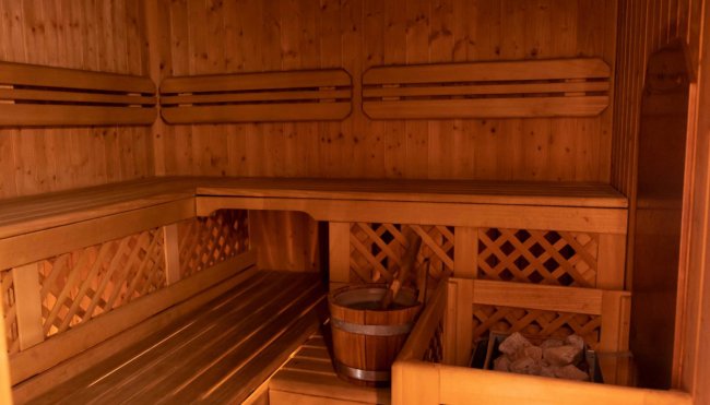 Sauna in legno con secchio e pietre.