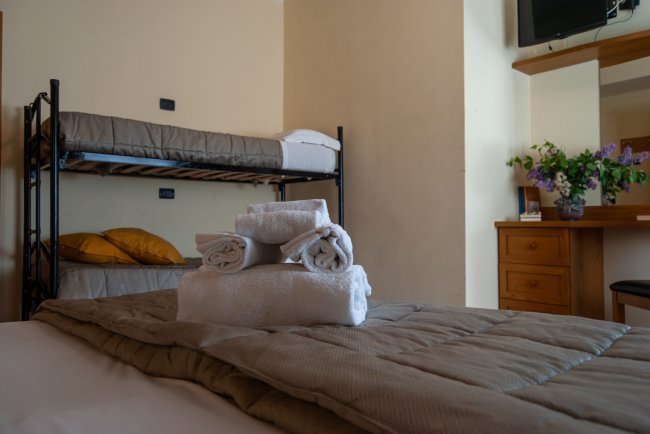 Camera con letti a castello e asciugamani sul letto.