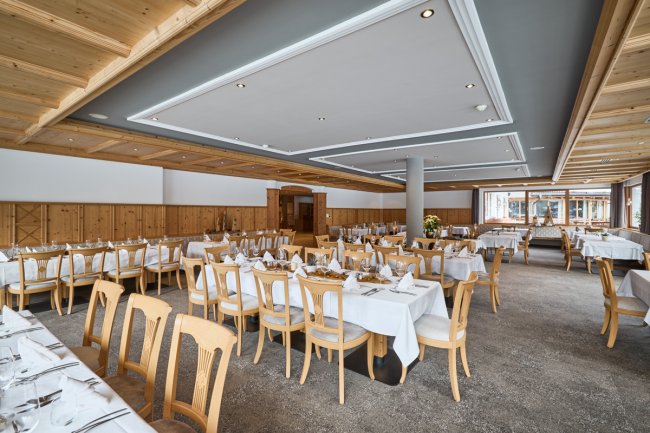Sala da pranzo elegante con tavoli apparecchiati.
