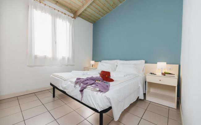 Stanza con letto matrimoniale e parete blu.