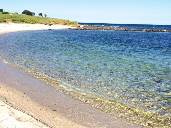 Spiaggia sabbiosa e mare cristallino.