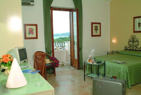 Camera d'albergo con letto matrimoniale, finestra aperta su vista lago.