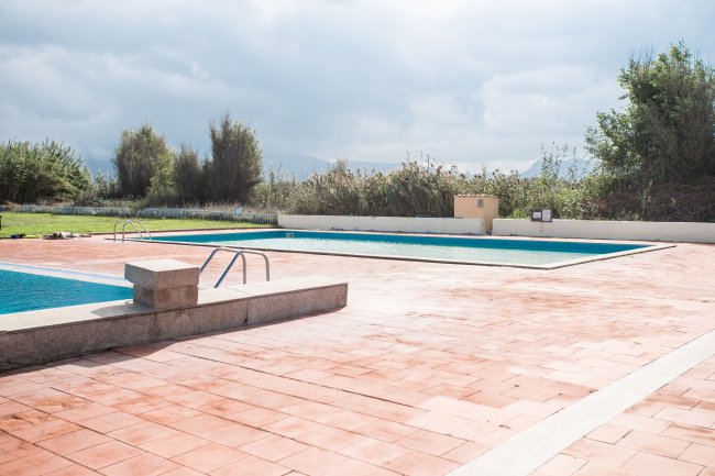 Piscina all'aperto con cielo nuvoloso.