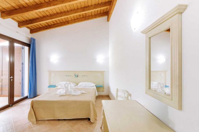 Camera da letto con travi in legno e specchio.
