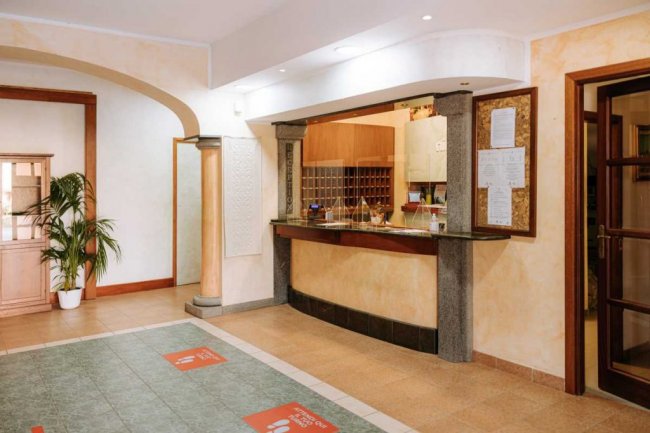 Reception di un hotel con banco e decorazioni.