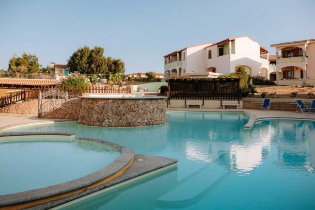 Piscina con edifici residenziali sullo sfondo.