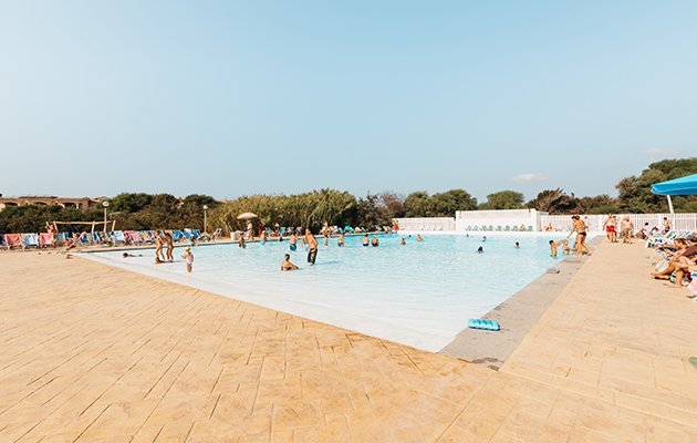 Piscina all'aperto con persone che nuotano.