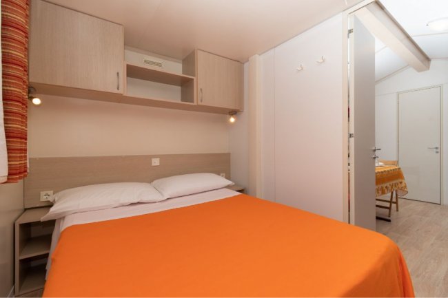 Camera da letto con letto matrimoniale e arredi semplici.