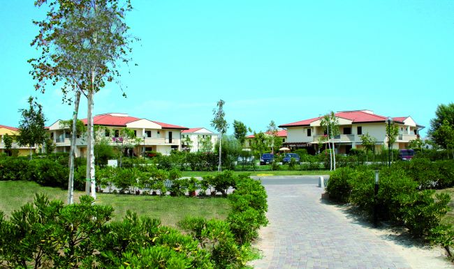 Complesso residenziale con giardino e camminamento centrale.