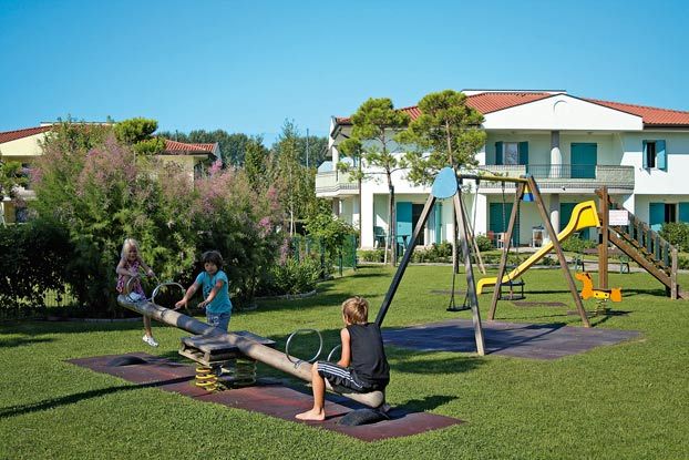 Bambini giocano su un'altalena in un parco giochi.