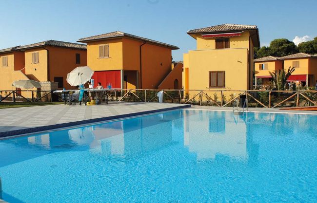 Piscina ampia con edifici color ocra sullo sfondo.