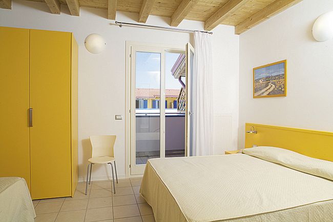 Camera da letto con letto matrimoniale e balcone.