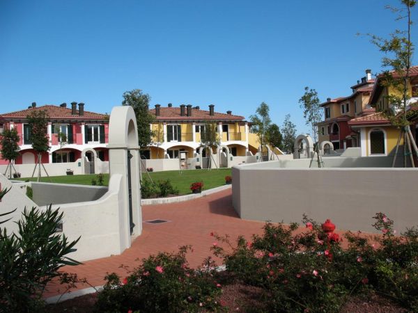 Case colorate con archi e giardini curati.