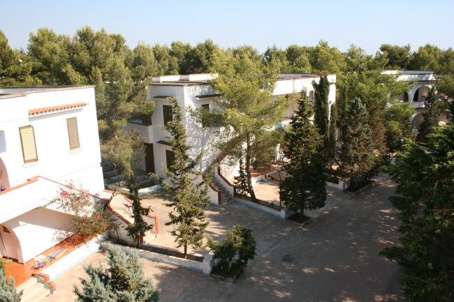 Complesso residenziale tra alberi alti.