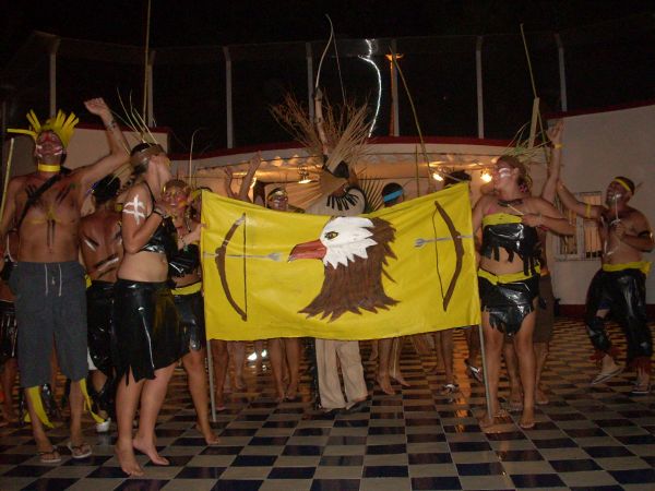 Gruppo in costume tradizionale con bandiera di un'aquila su sfondo giallo.
