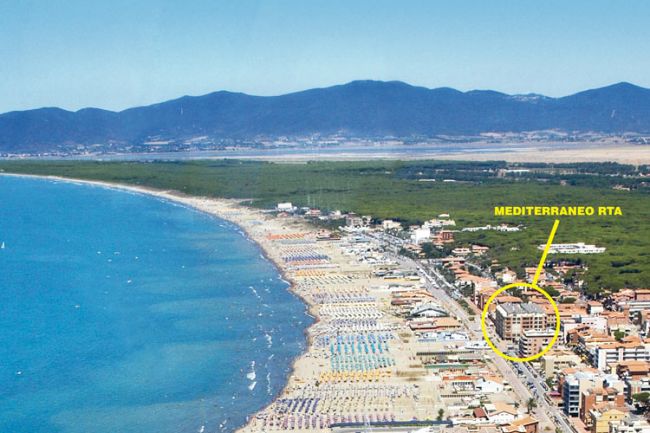 Vista aerea di una spiaggia con mare azzurro e indicazione della posizione di un edificio.