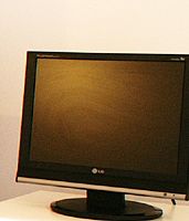 Uno schermo di computer LG spento, appoggiato su una scrivania bianca.