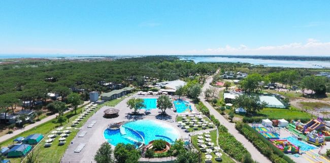 Complesso turistico con piscina, verde e vialetti.