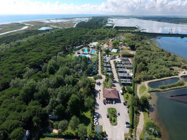 Veduta aerea di un complesso con verde e laguna.