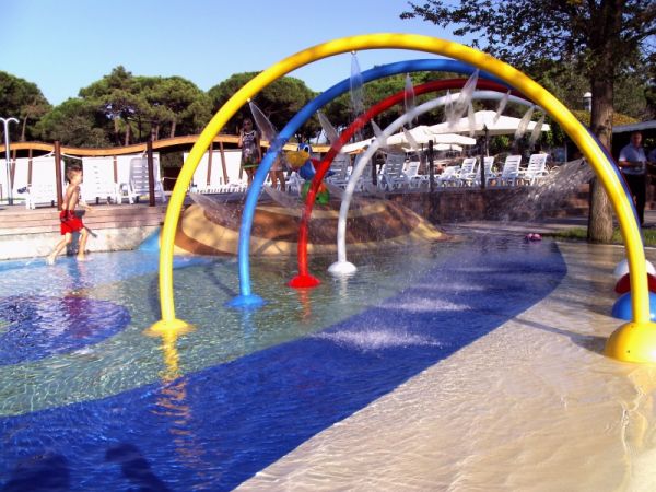 Area giochi d'acqua con archi colorati.