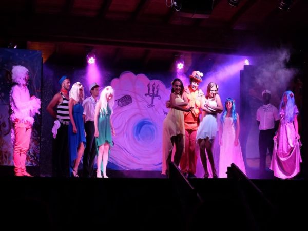 Spettacolo teatrale con attori in costume colorato.