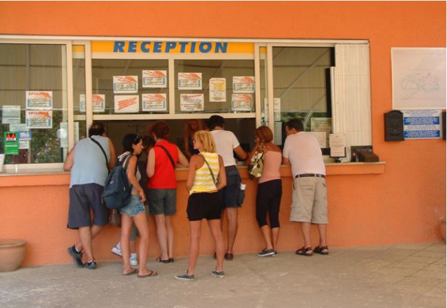 Persone in fila alla reception.