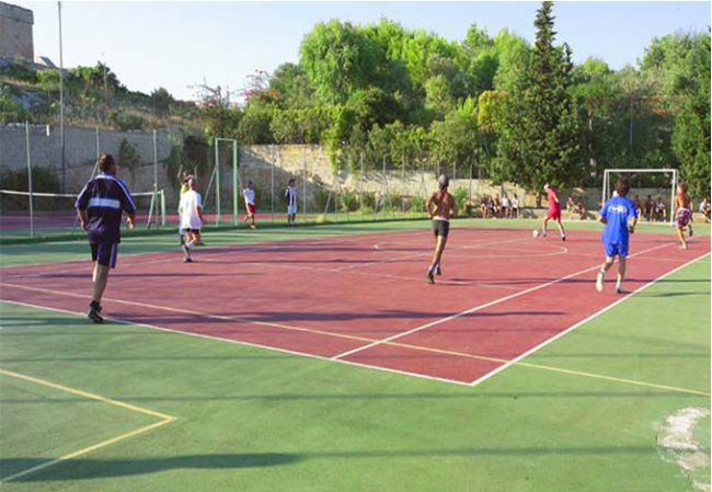 Un campo sportivo all'aperto con persone che giocano a calcio.