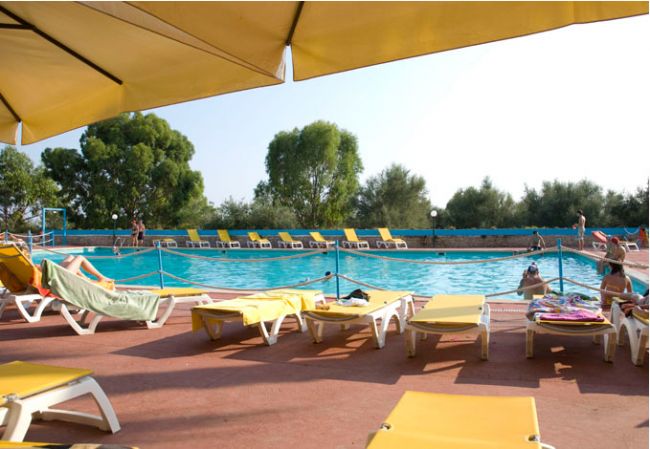 Piscina circondata da lettini e ombrelloni gialli.