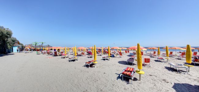Spiaggia con ombrelloni gialli e lettini.