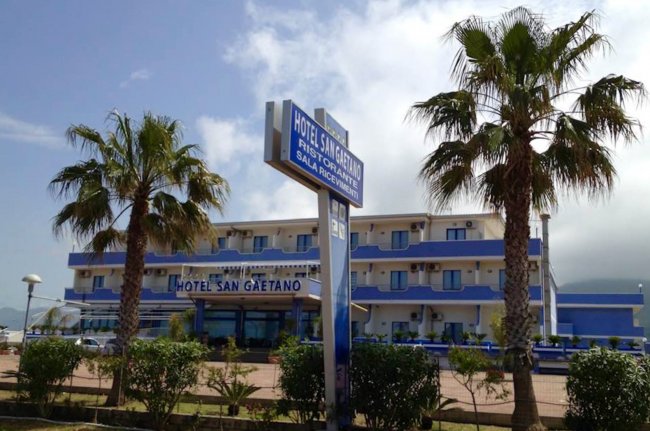 Hotel San Gaetano con palme e insegna frontale.