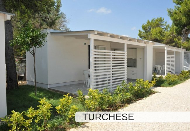 Bungalow moderno bianco con veranda e giardino.