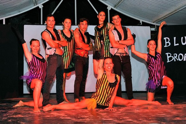 Gruppo di ballerini posano su un palco.