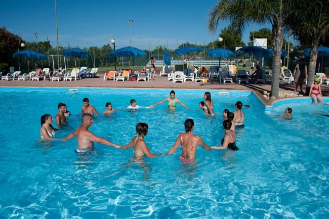Persone in cerchio in una piscina all'aperto.