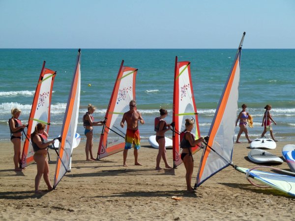 Persone praticano windsurf sulla spiaggia.