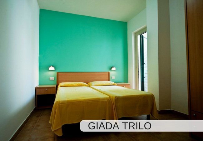 Stanza con due letti singoli, parete verde.
