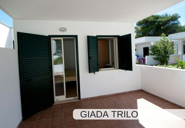 Terrazzino con porte e finestre verdi.
