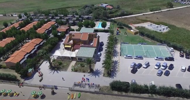 Veduta aerea di un complesso turistico con campi sportivi e parcheggio.