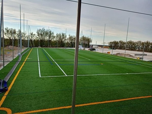 Campo da calcio in erba sintetica con recinzione.