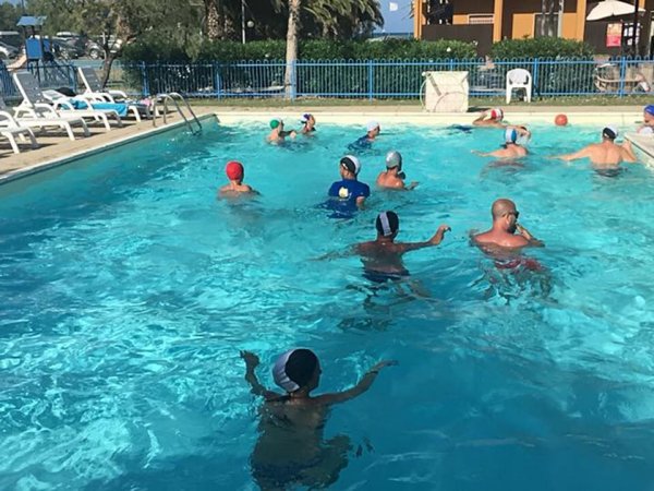 Persone giocano a pallanuoto in piscina.