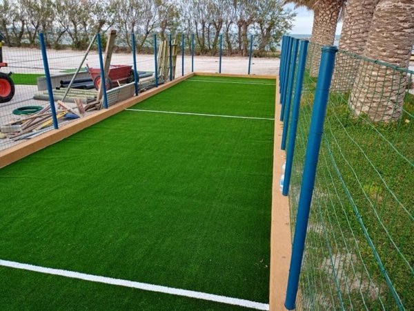 Campo da gioco con erba sintetica e recinzione.