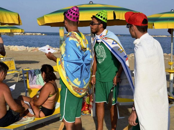 Persone in spiaggia con cappelli colorati.