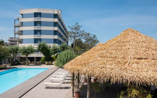 Piscina all'aperto accanto a un hotel moderno.