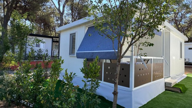 Modulo abitativo bianco con giardino.