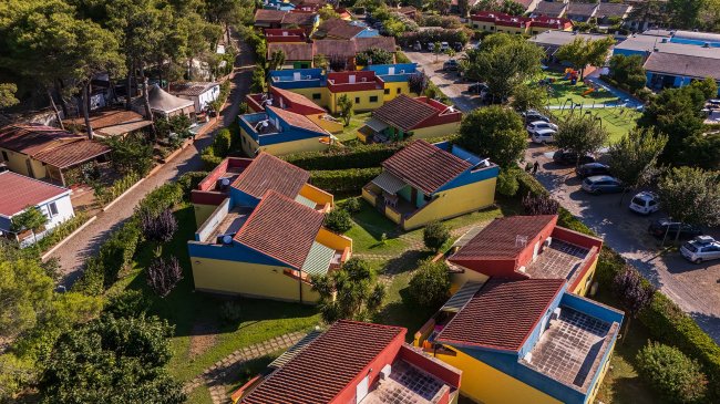 Vista dall'alto di case colorate tra alberi.
