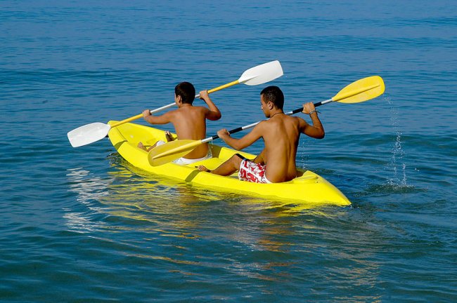 Due persone remano in kayak giallo sull'acqua.